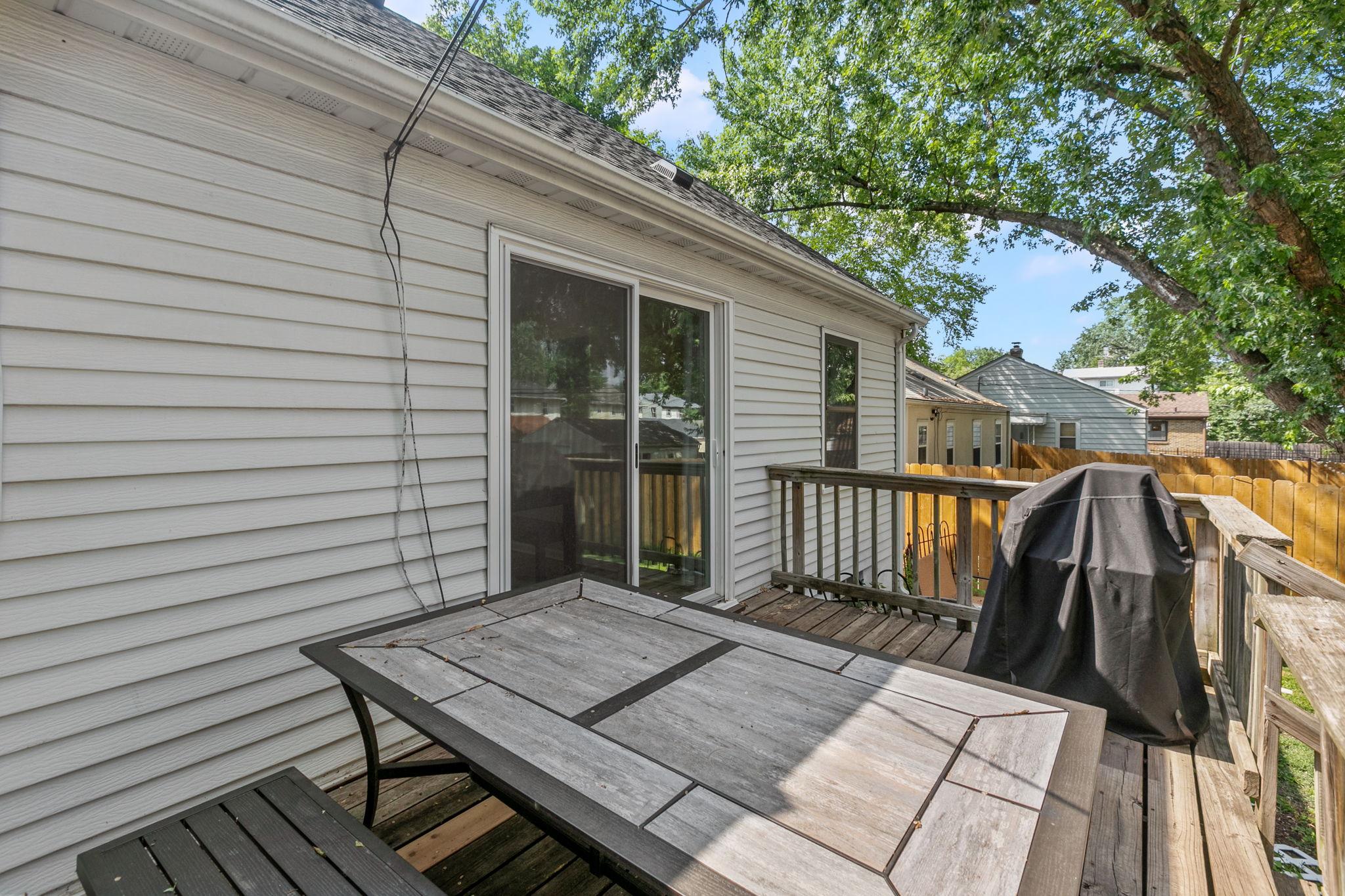A large wooden rear deck, circular paver patio, and full-coverage wooden steel-post privacy fence mean you're equipped for entertaining, gardening, and pets at 5549 27th Avenue S.
