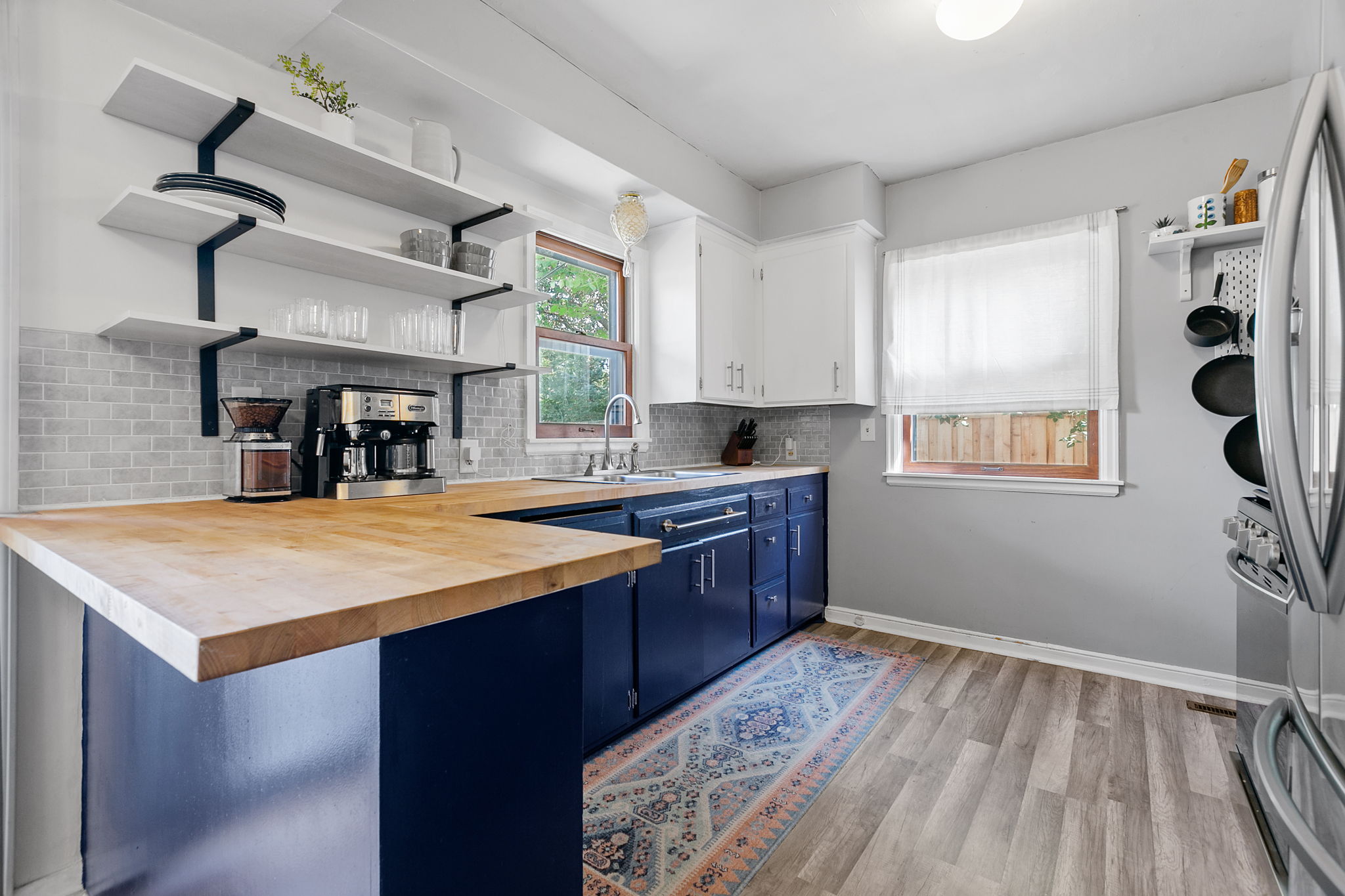 The kitchen at 5549 27th Avenue S combines stainless steel appliances with deep-blue lower cabinets and butcher-block countertops.