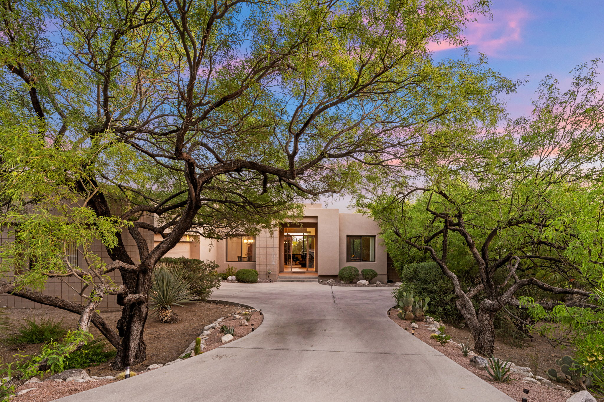 The home is framed by mature landscaping