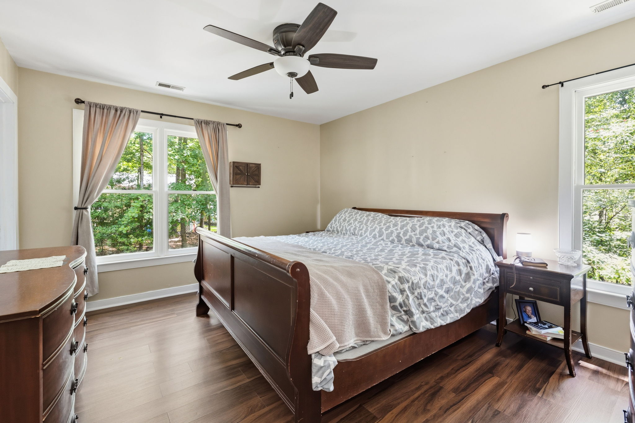 Primary suite with large walk in closet, ceiling fan, and attached full bath.