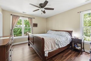 Primary suite with large walk in closet, ceiling fan, and attached full bath.
