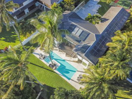 Aerial view of this lovely oceanfront home with XL pool & backyard
