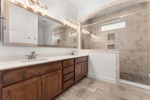 The primary bathroom has a custom shower, double vanity, quartz counters, new lighting, and fresh paint.