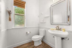 The half bathroom is located in the front of the home between the office and kitchen.