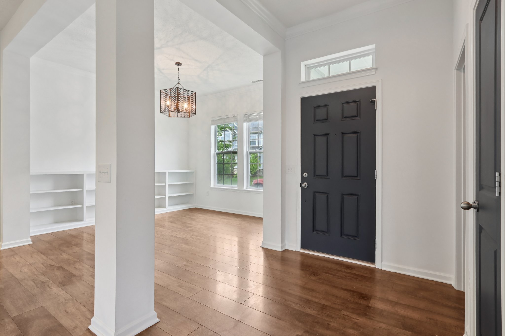 Step inside to soaring ceilings, elegant hardwoods, and a versatile front den or flex space bathed in natural light