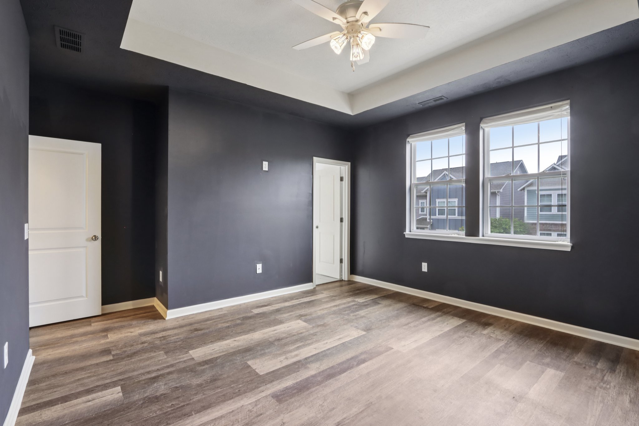 Gorgeous primary retreat with rich tones, tray ceiling, and abundant natural light.