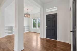 Step inside to soaring ceilings, elegant hardwoods, and a versatile front den or flex space bathed in natural light