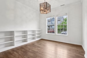 Bright and airy flex space with built-in shelving, ideal for a home office, playroom, or formal dining.