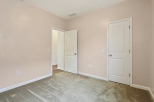 Spacious guest bedroom with walk-in closet—perfect for guests, teens, or a stylish home office.