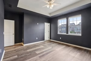 Gorgeous primary retreat with rich tones, tray ceiling, and abundant natural light.