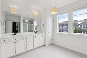 Bright and elegant ensuite featuring a double vanity, ample storage, and plenty of morning sunlight.