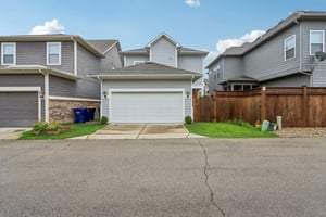 Two-car garage with alley access and fenced-in yard—function meets security.