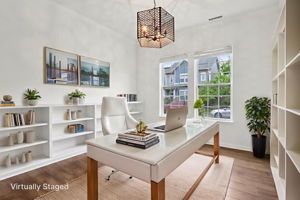 Bright and airy flex space with built-in shelving, ideal for a home office, playroom, or formal dining. virtually staged watermark