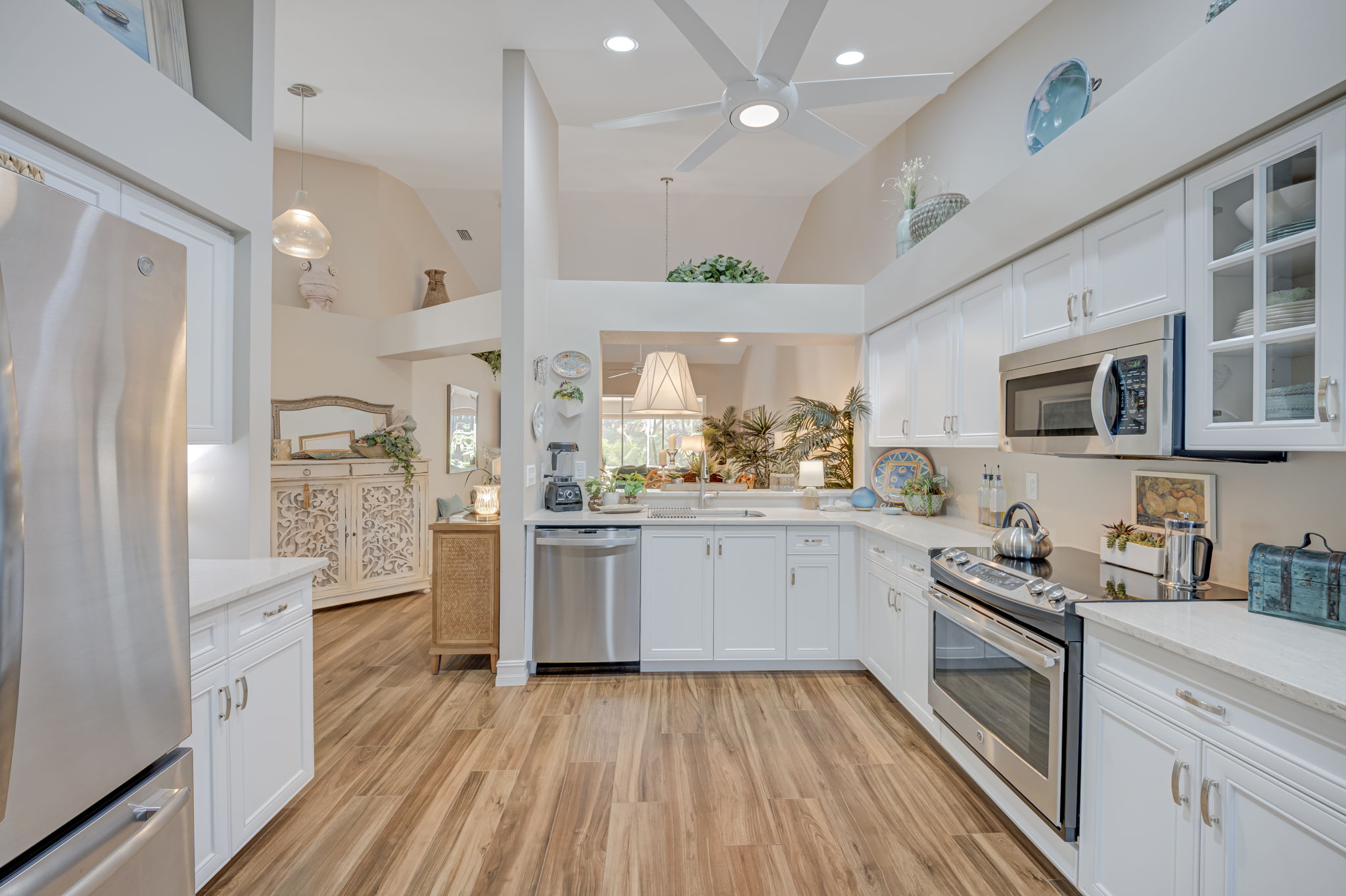 Fully updated chef's kitchen boasting white cabinetry, premium countertops, tile floors, and a modern stainless steel appliance package