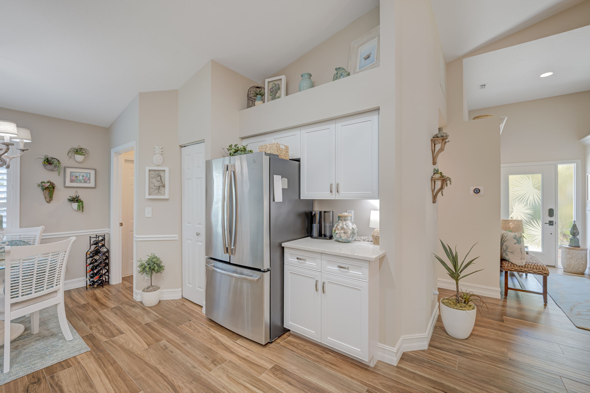 Another view of the kitchen area, pantry, laundry room access, and hallway towards the front door
