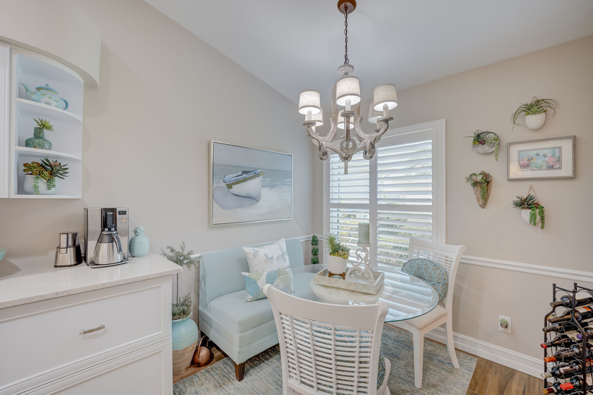 Bright eat-in kitchen with extended countrtops, nook featuring large energy-efficient windows with plantation shutters,luxury tile floors, and space for casual dining