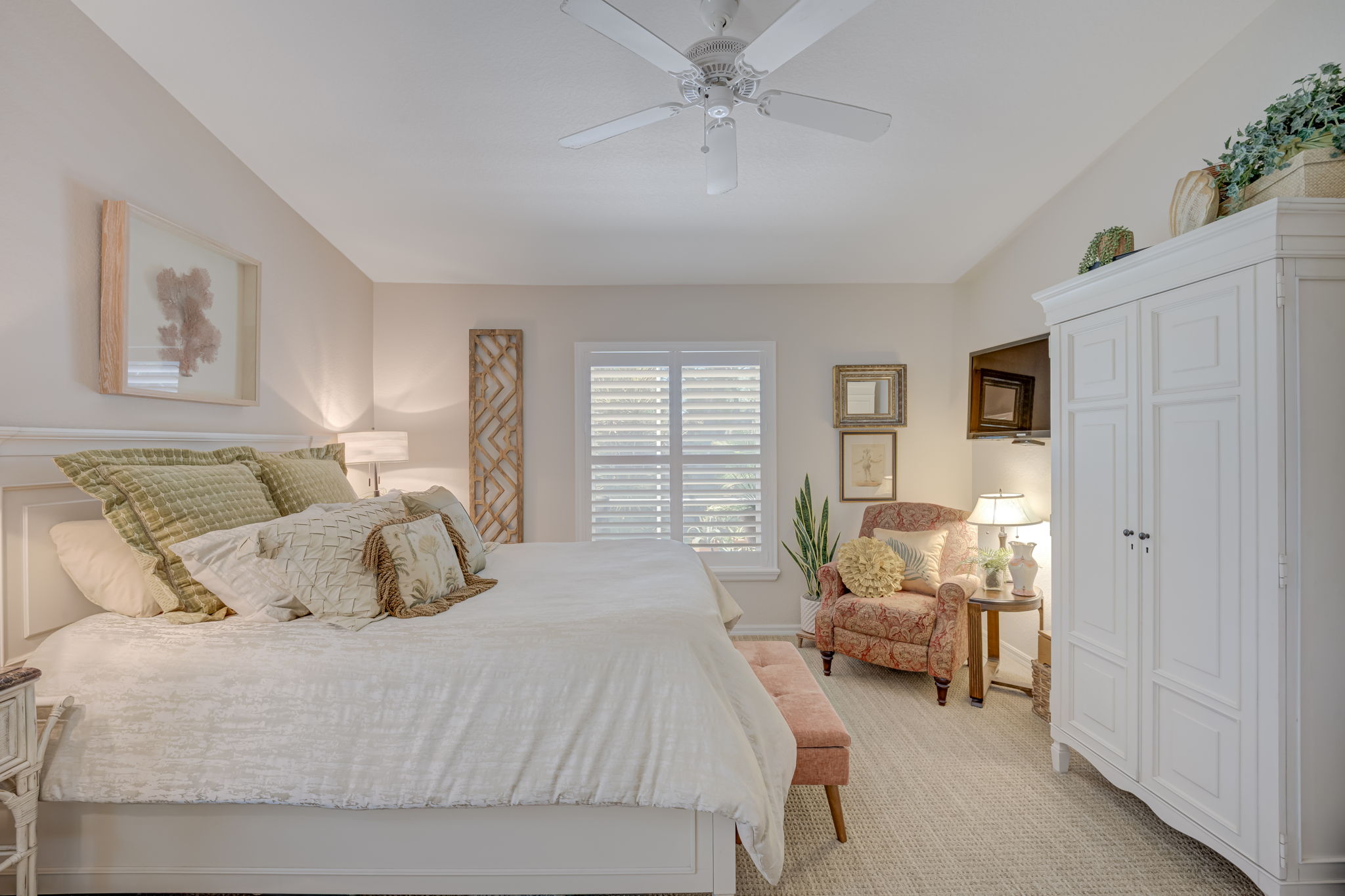 Alternate view of the spacious primary suite highlighting the volume ceiling details