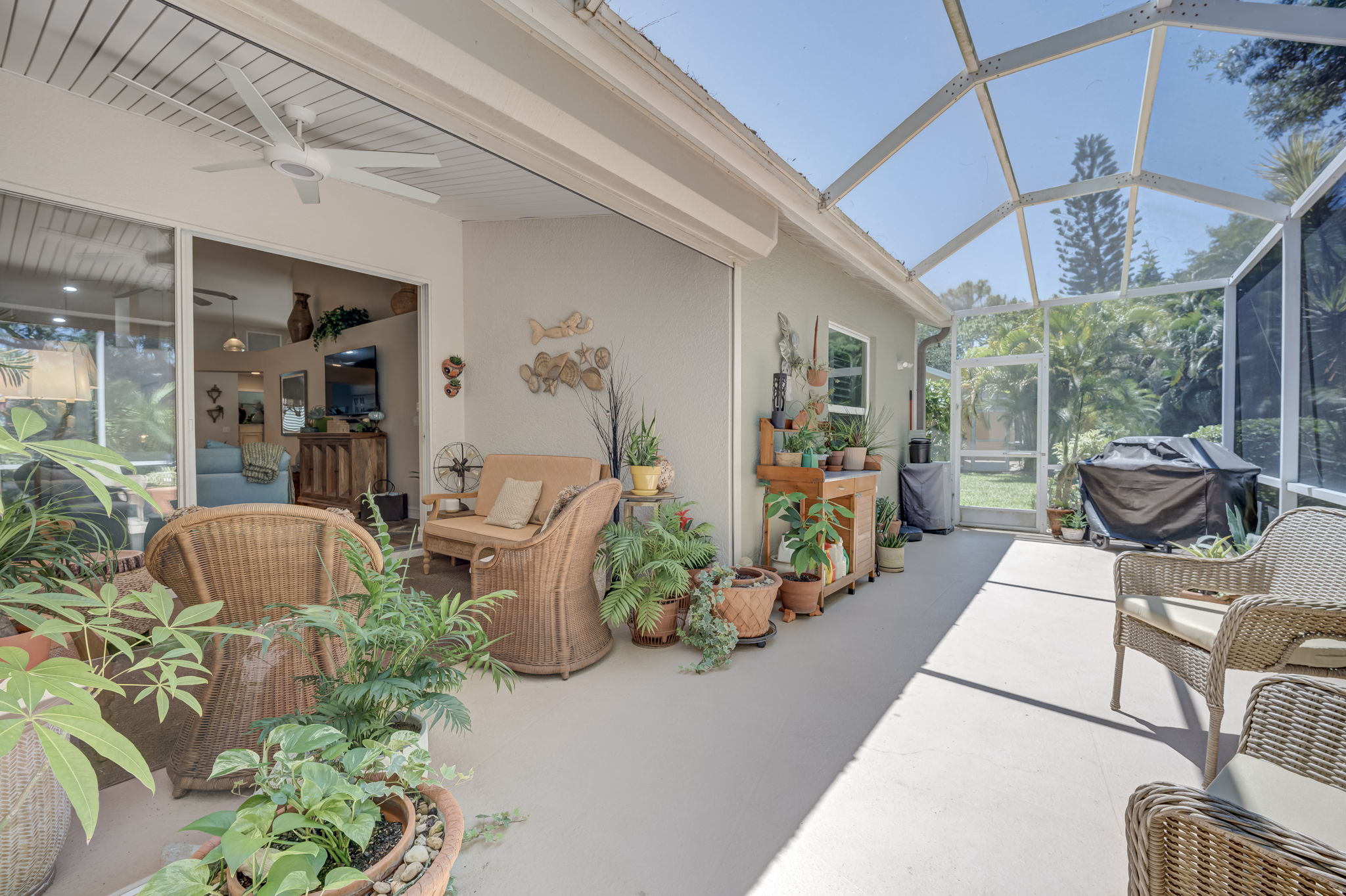 Fully screened-in outdoor lanai space featuring durable concrete decking, perfect for bug-free alfresco dining and entertaining