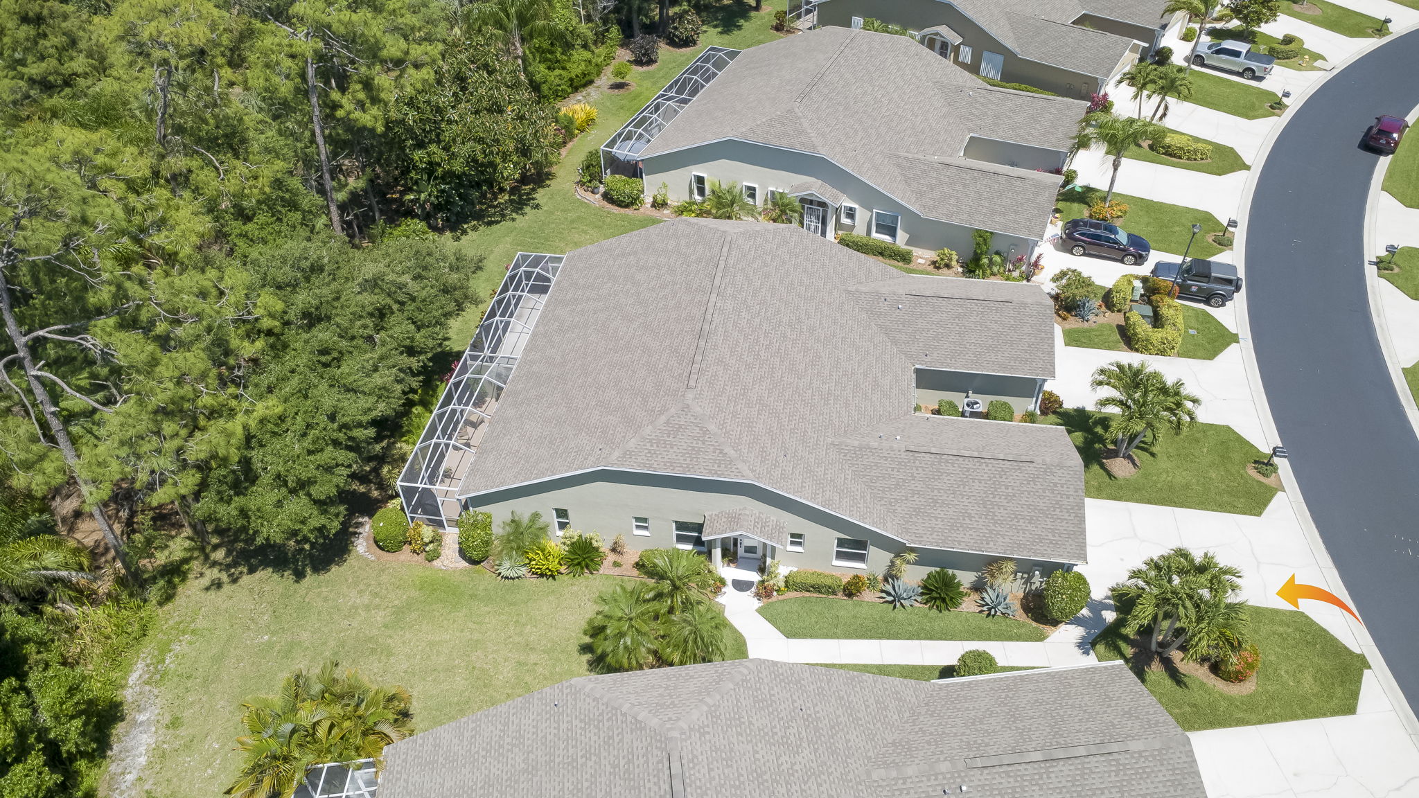 High-angle drone shot detailing the property's generous lot size and its integration into the manicured, sidewalk-lined residential community.