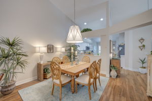 Formal dining area seamlessly integrated into the open floor plan, illuminated by a designer coastal chandelier, and new tile flooring