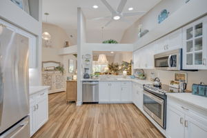 Fully updated chef's kitchen boasting white cabinetry, premium countertops, tile floors, and a modern stainless steel appliance package