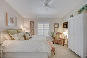 Alternate view of the spacious primary suite highlighting the volume ceiling details