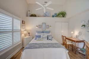Front bedroom with large impact window featuring plantation shutters, new tile flooring