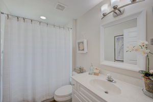 Full guest bathroom featuring premium fixtures, and a pristine low-maintenance tub-shower combination