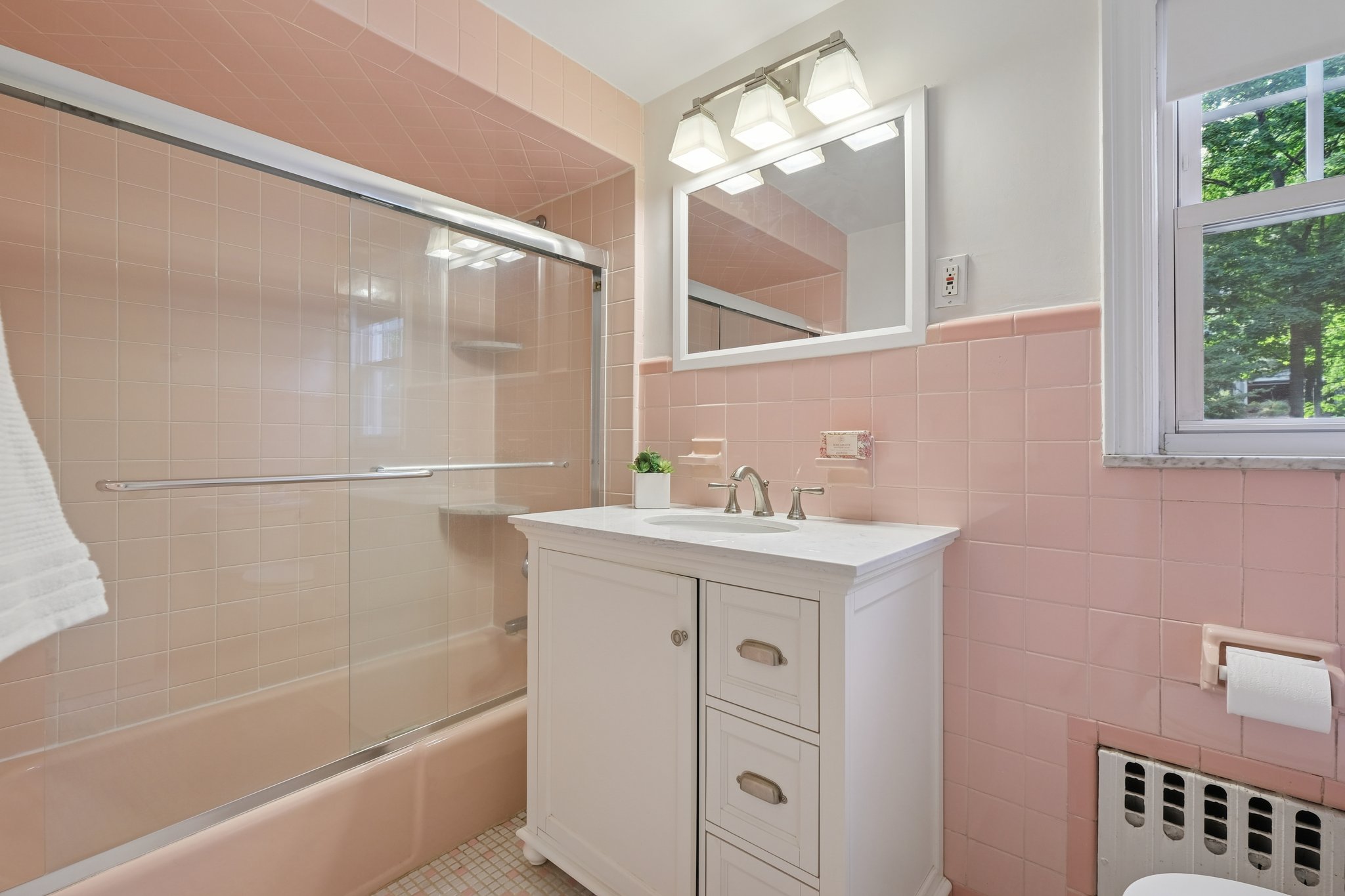 Think Barbie Dreamhouse meets vintage chic - original pink tile still holding court in 2nd floor hall bath..