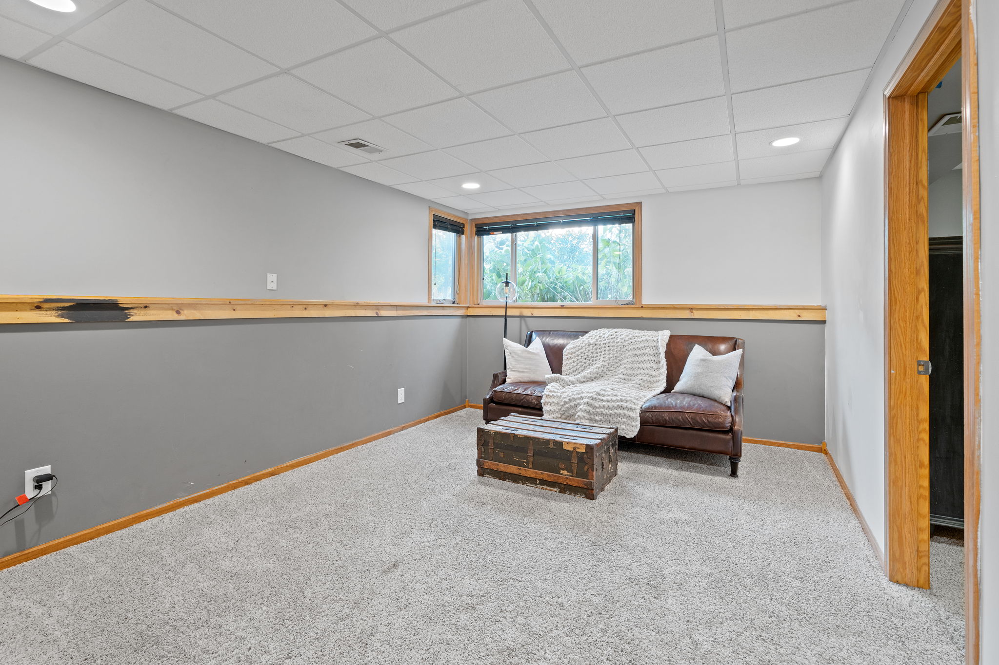 The finished basement at 5857 Oneka Lake Boulevard N begins with a spacious, wide family room without sacrificing on natural light.