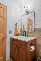 The upper-level full bathroom at 5857 Oneka Lake Boulevard N features a nice wide vanity with a tiled shower surround that goes all the way to the ceiling.