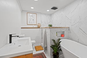 The lower level at 5857 Oneka Lake Boulevard N features this newly renovated full bathroom, complete with a large soaker tub and a separate shower stall with a ceiling-mounted rain shower head.