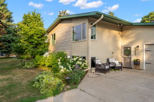 Lush gardens pair with bonus patio space along the front elevation of 5857 Oneka Lake Boulevard N.