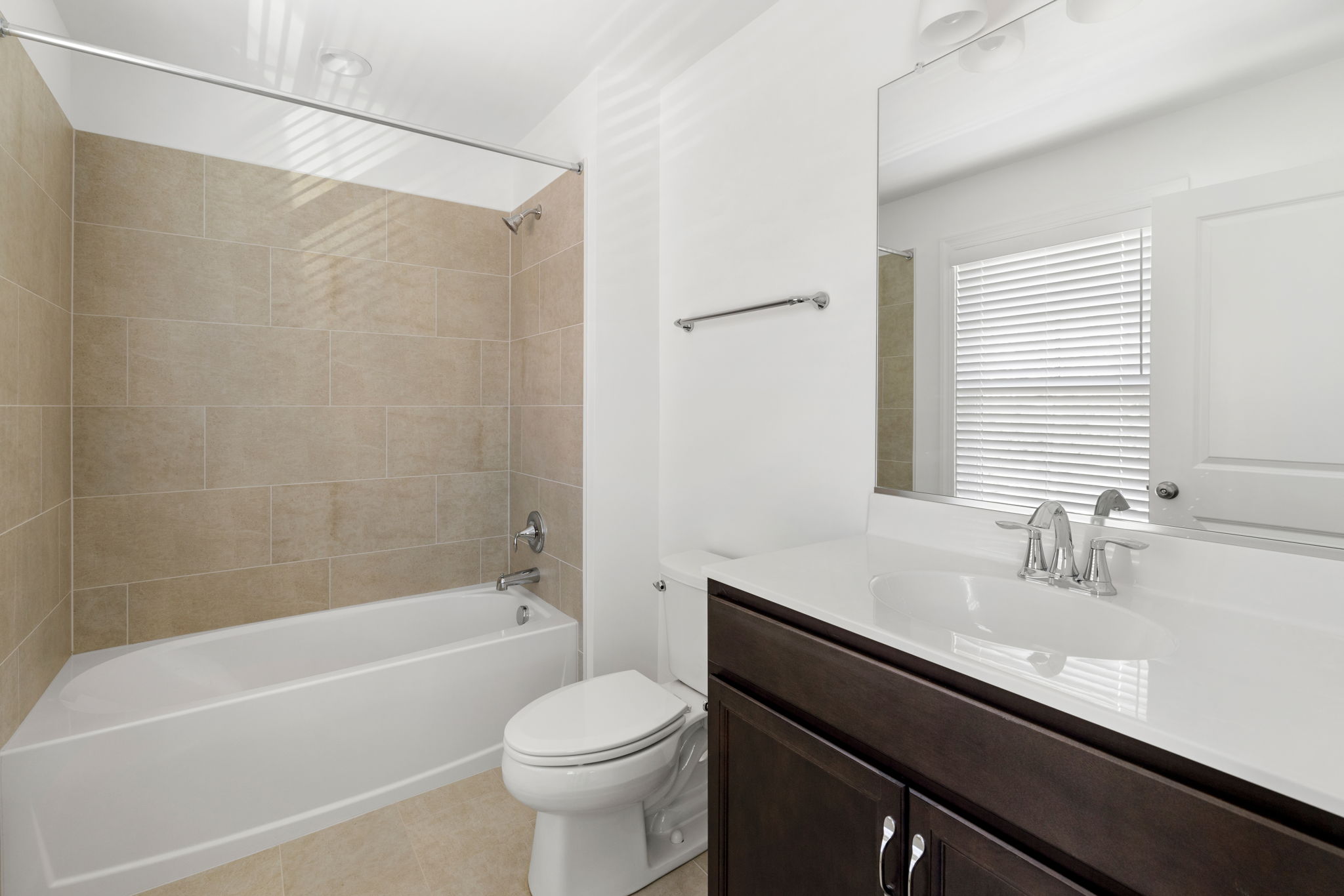 En-suite primary bathroom with tile and tub/shower combo.
