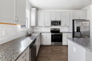 Kitchen features granite counter-tops, GE SS appliances, and a large island.