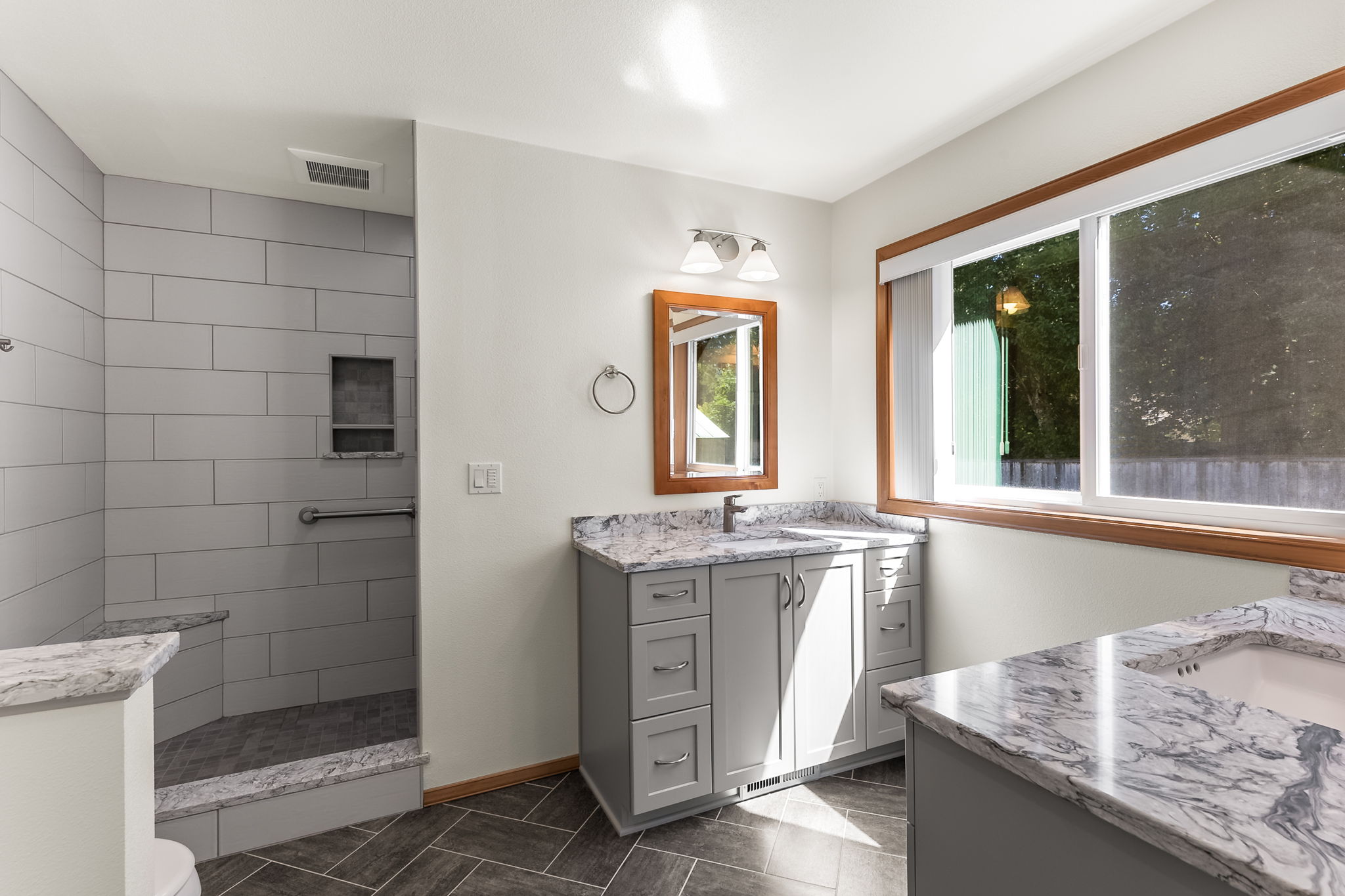 Updated primary bath with two separate Quartz undermount sinks.
