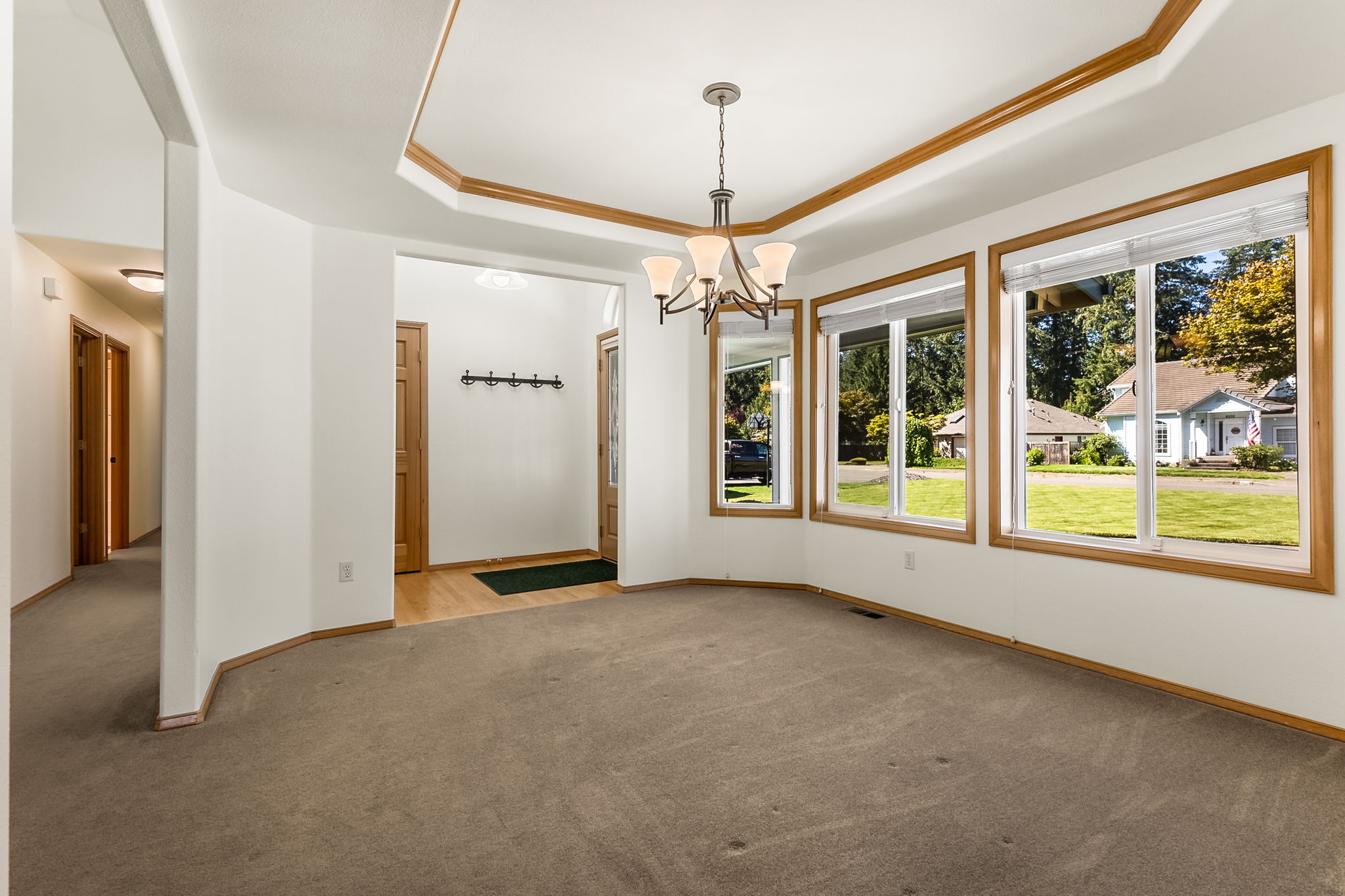 Formal dining room with wood trimmed trayed ceiling and large windows. All windows were replaced just 5 years ago!