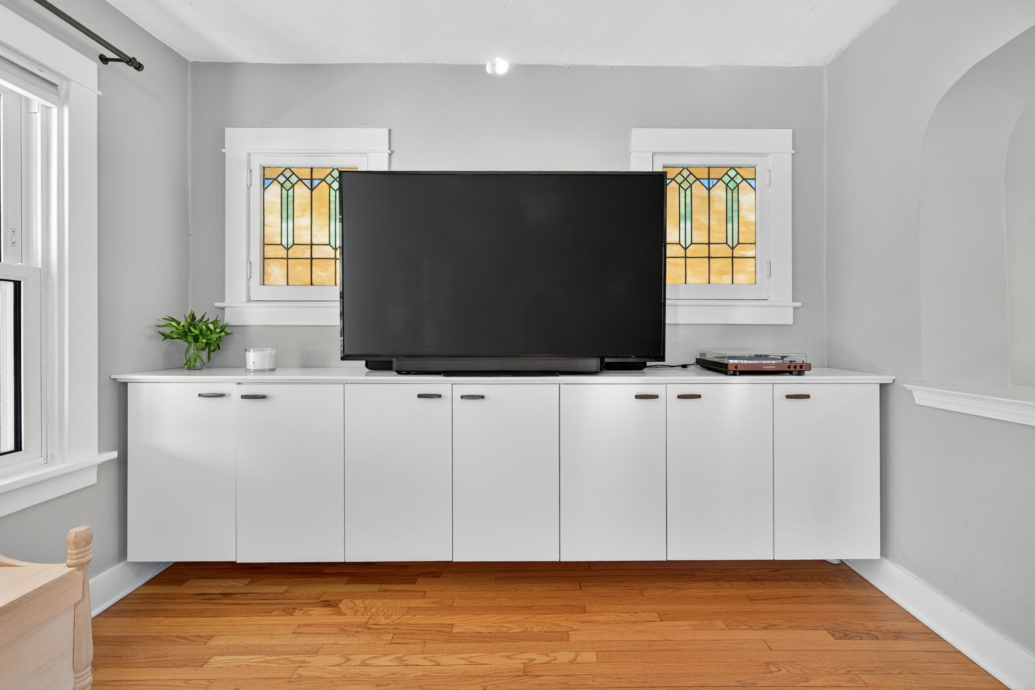 The living room also features built-in storage galore adorned by the spectacular original stained glass windows.