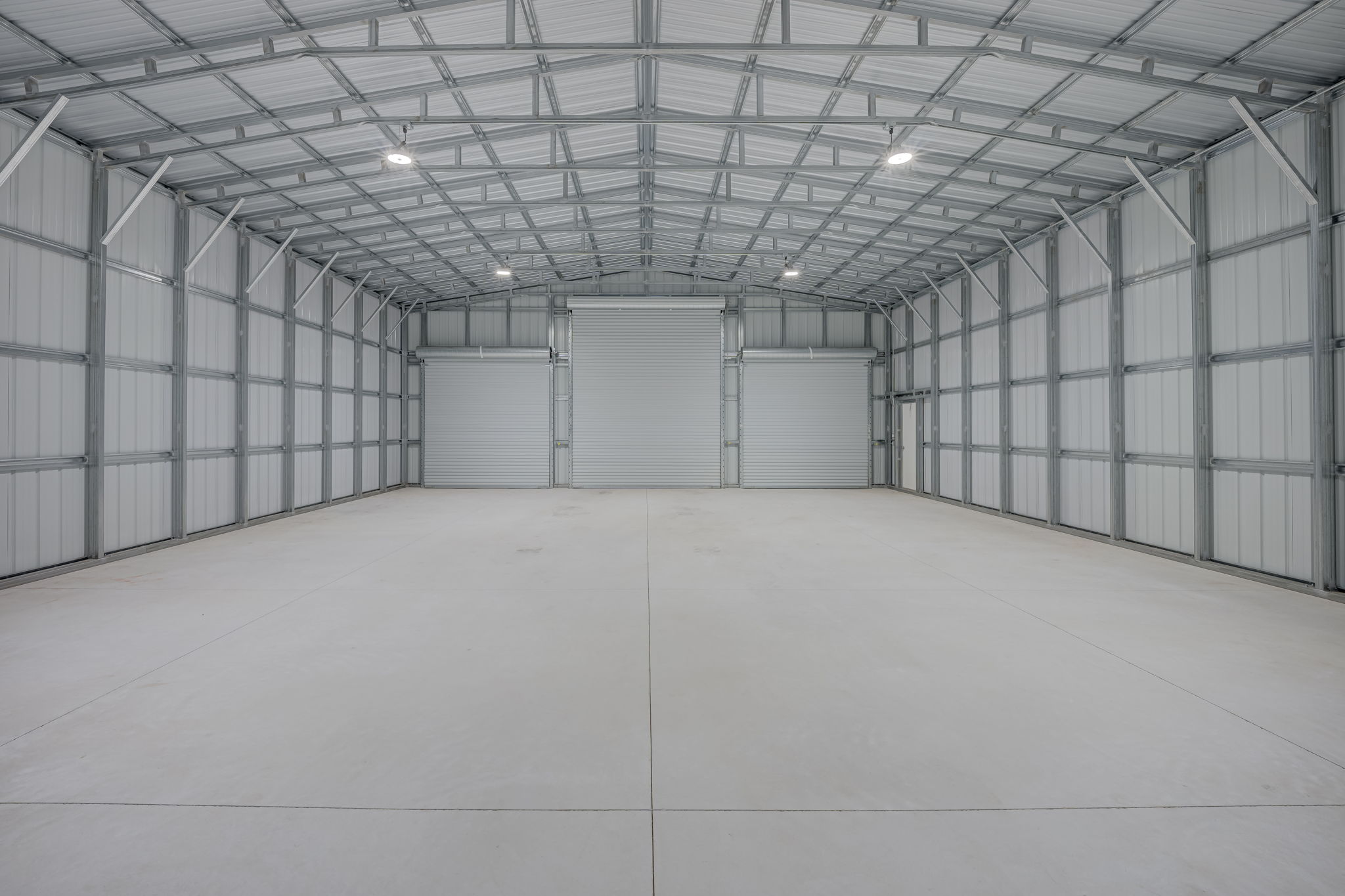Comprehensive interior view highlighting the high vaulted ceilings, structural steel trusses, and premium wall insulation.