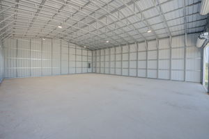 Deep interior shot of the clear-span warehouse showing the reinforced concrete slab flooring and exposed heavy-duty steel framing.