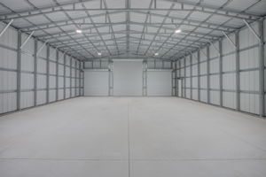 Comprehensive interior view highlighting the high vaulted ceilings, structural steel trusses, and premium wall insulation.