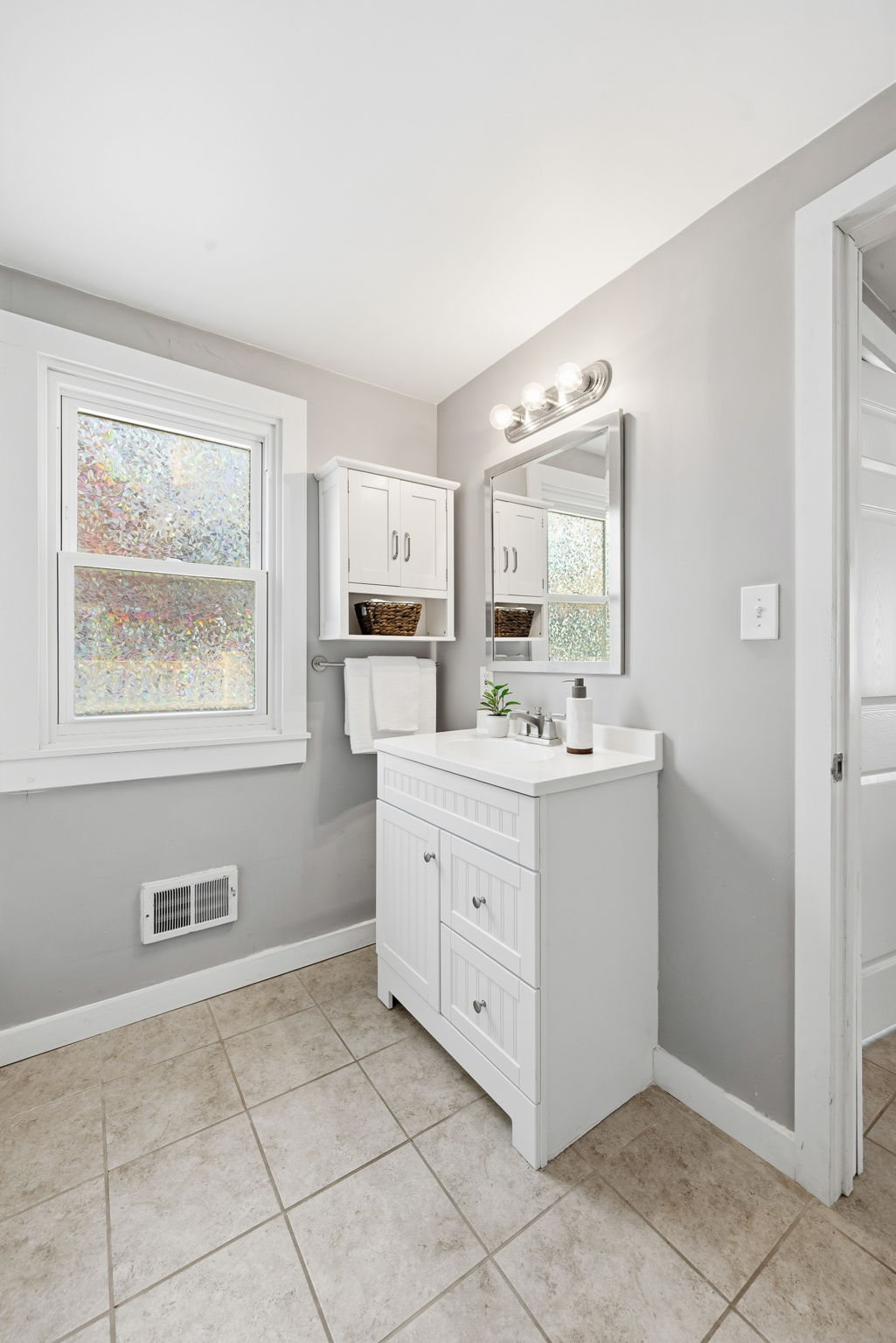 The bathroom is spacious with a linen closet and room if you want a larger vanity.