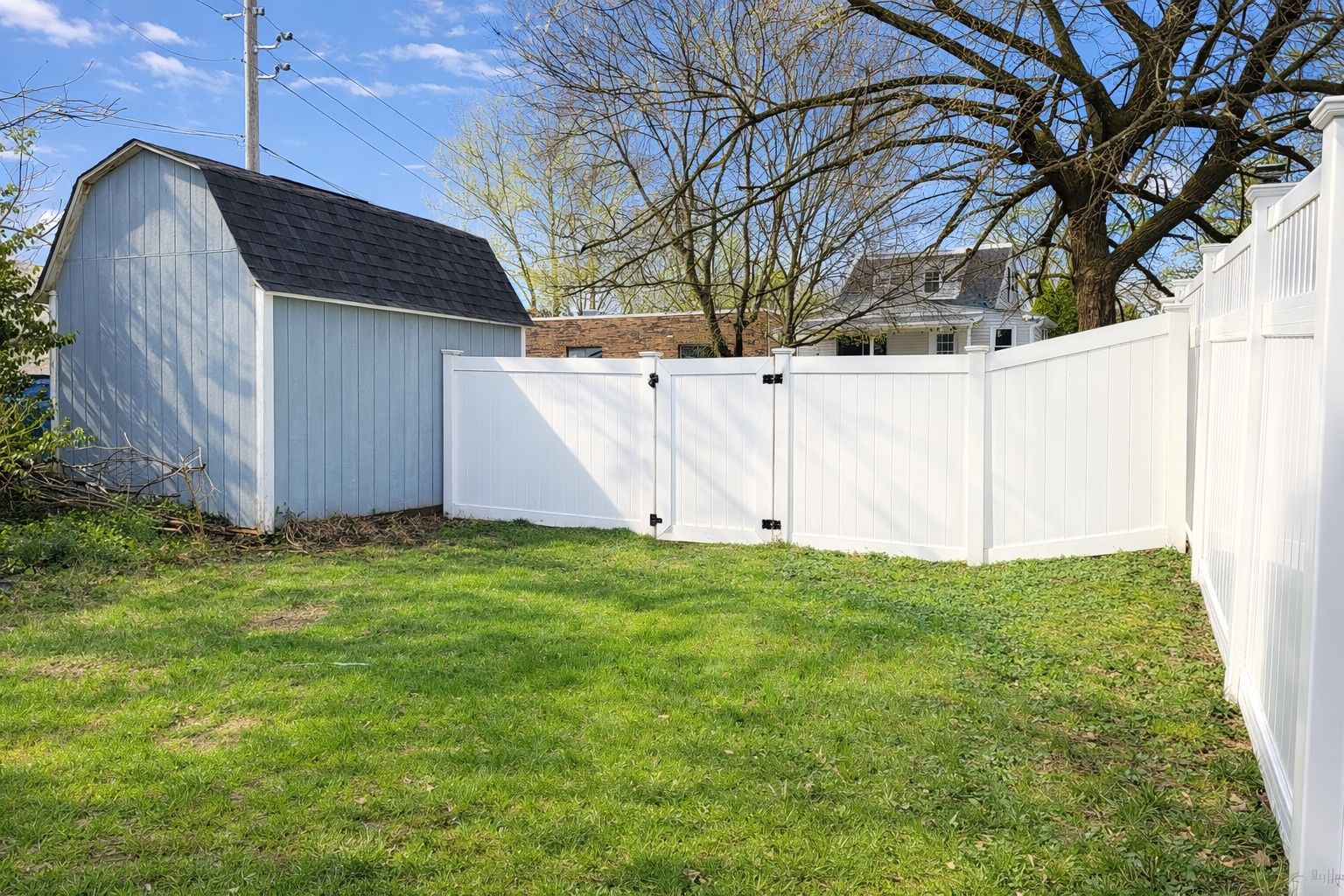 There is a private parking area behind the shed and fence for two cars. Add concrete, gravel, a carport, or garage!