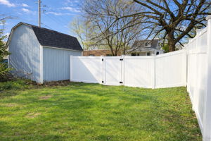 There is a private parking area behind the shed and fence for two cars. Add concrete, gravel, a carport, or garage!
