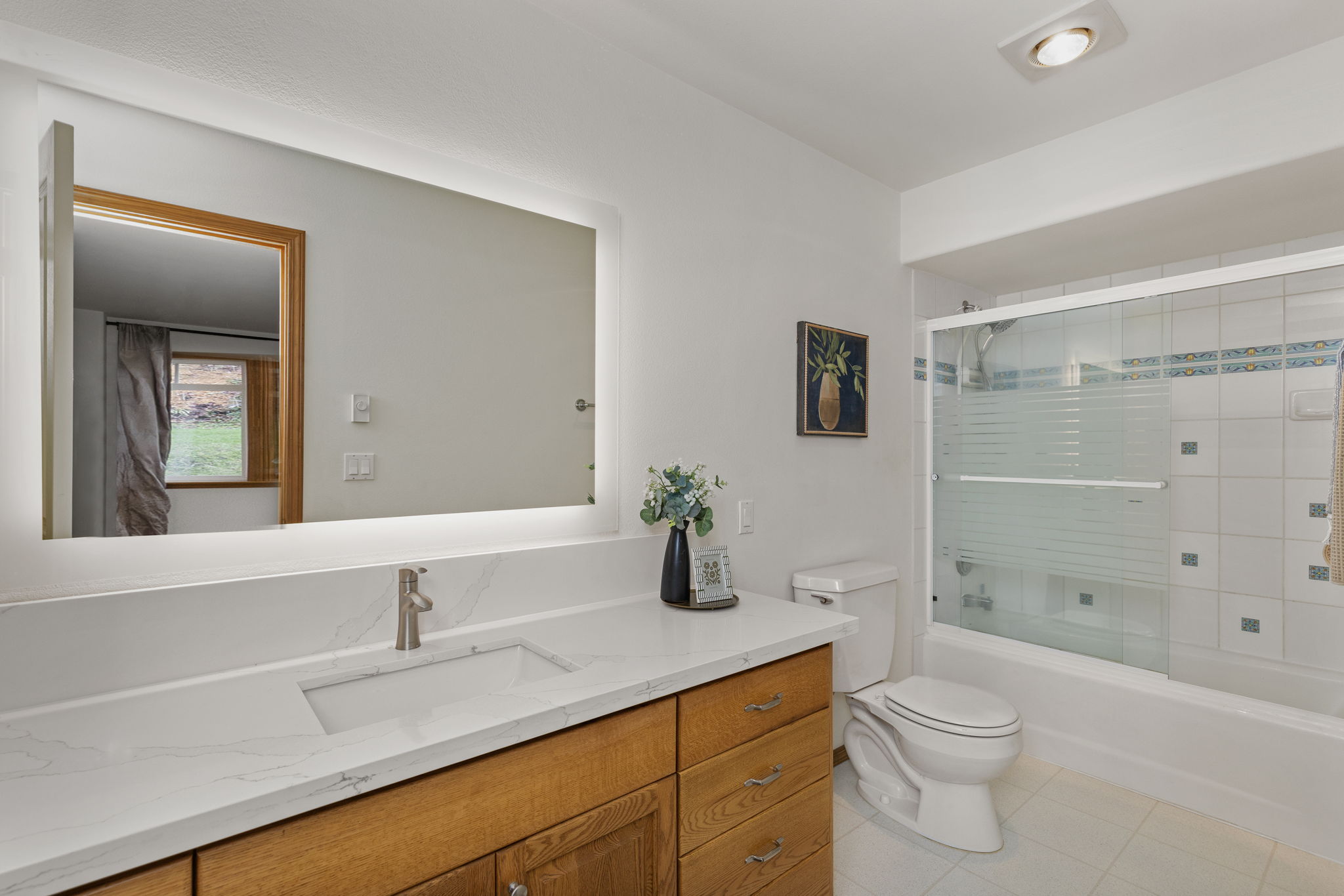 Main floor primary bath with quartz countertops.