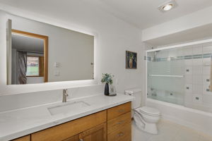 Main floor primary bath with quartz countertops.