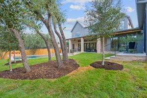 Mature and newly planted live oaks throughout the front and backyard
