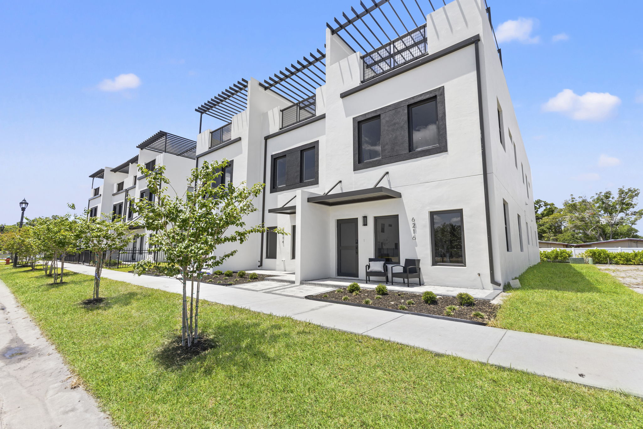 Front elevation and landscaped gated entry drive at Latitudes in the Park, Pinellas Park FL