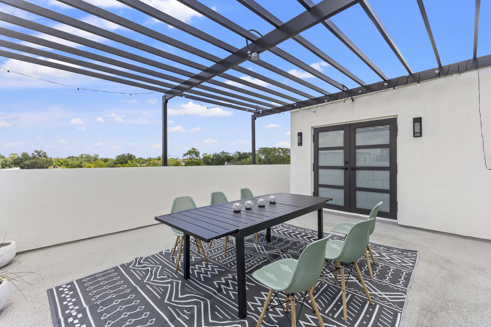 Alfresco dining table on the open half of a private rooftop terrace at Latitudes in the Park, Pinellas Park FL