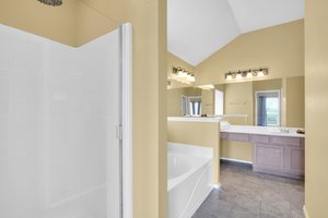 Primary bath features a garden tub & separate shower with waterfall panel